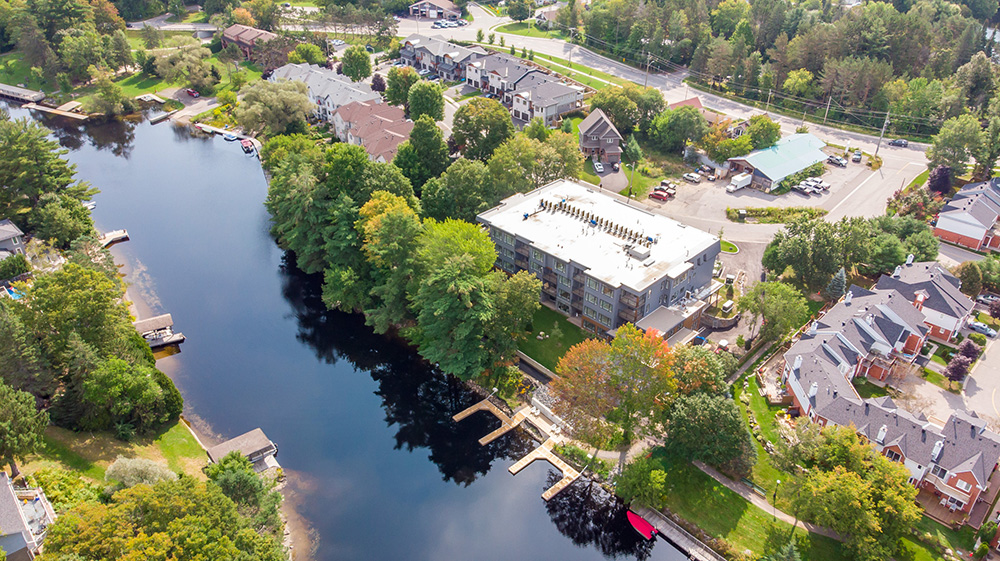 Riverside view of River’s Edge Bracebridge condos with boat dock and slips